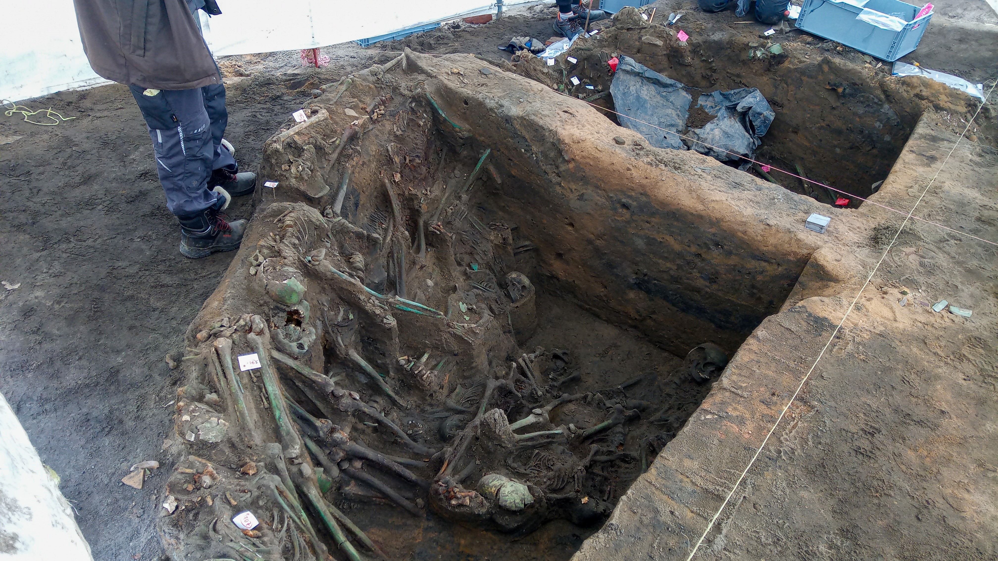 Одна из частично раскопанных ям, на которой видны тела, сложенные одно на другое.