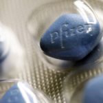 Close-up photo of blue pills of Viagra in a silver pill packet with Pfizer written on them
