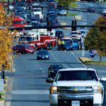 photo of a fire truck, ambulance and police vehicles blocking off traffic at an intersection where a crash appears to have taken place