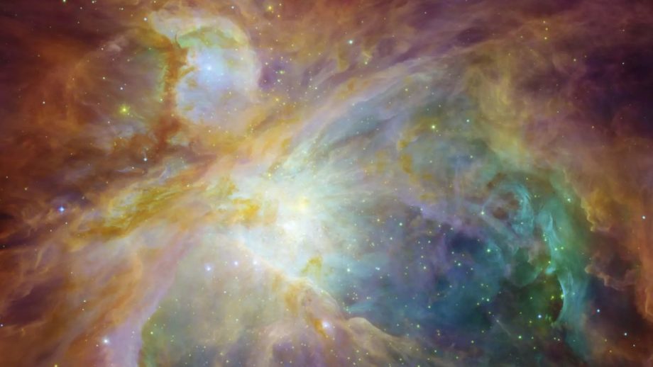 A Hubble Space Telescope image of the Orion Nebula shows swirling clouds of orange, blue, white and green dust in a field of twinkling stars