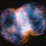 The Little Dumbbell Nebula, a colorful, barbell-shaped cloud of gas, as seen by the Hubble Space Telescope