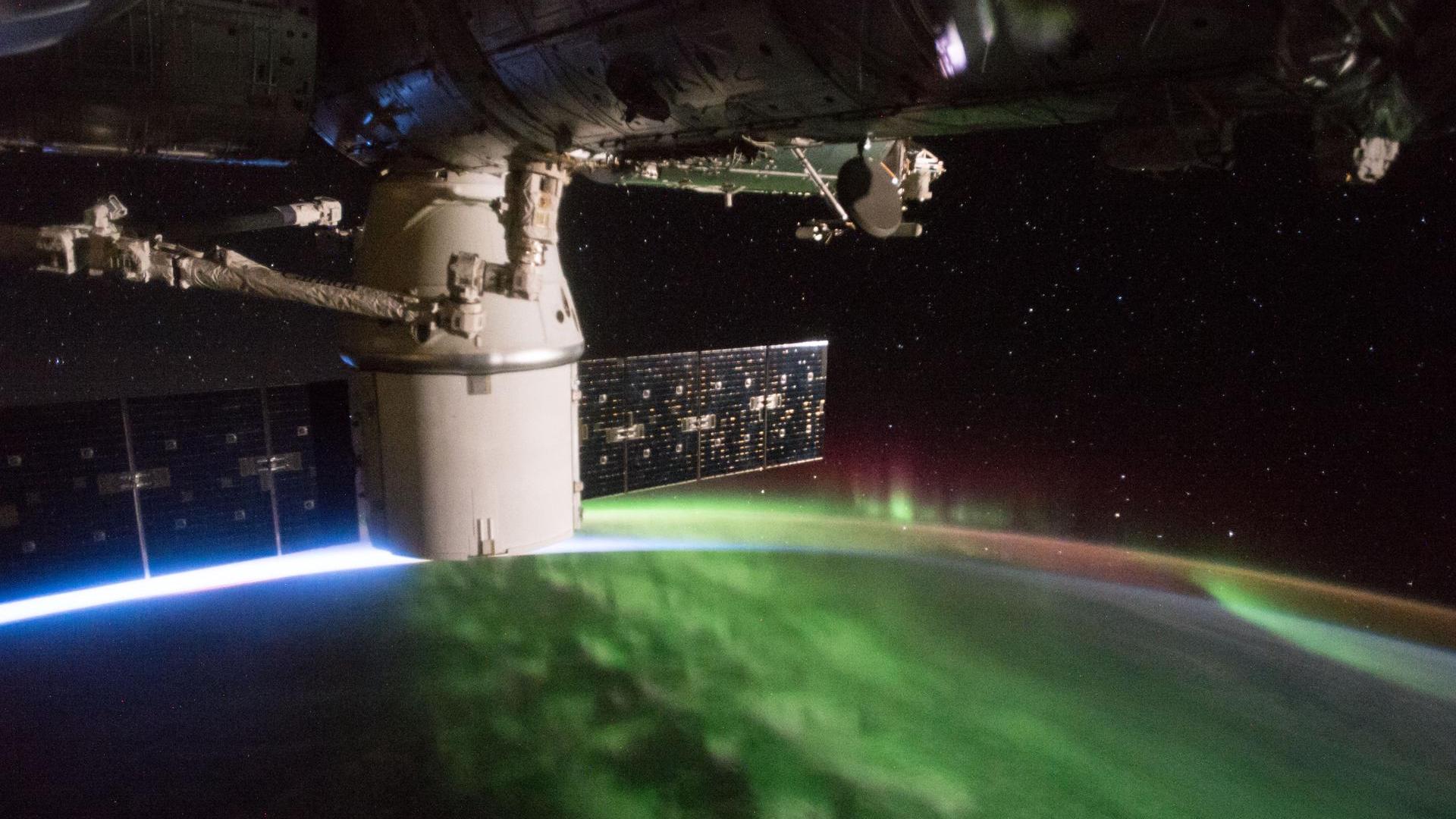 Фотография пурпурного и зеленого полярного сияния, сделанная с международной космической станции.