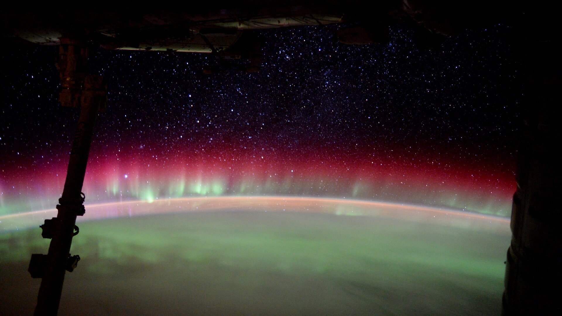 Фотография радужного полярного сияния, покрывающего одну сторону Земли.