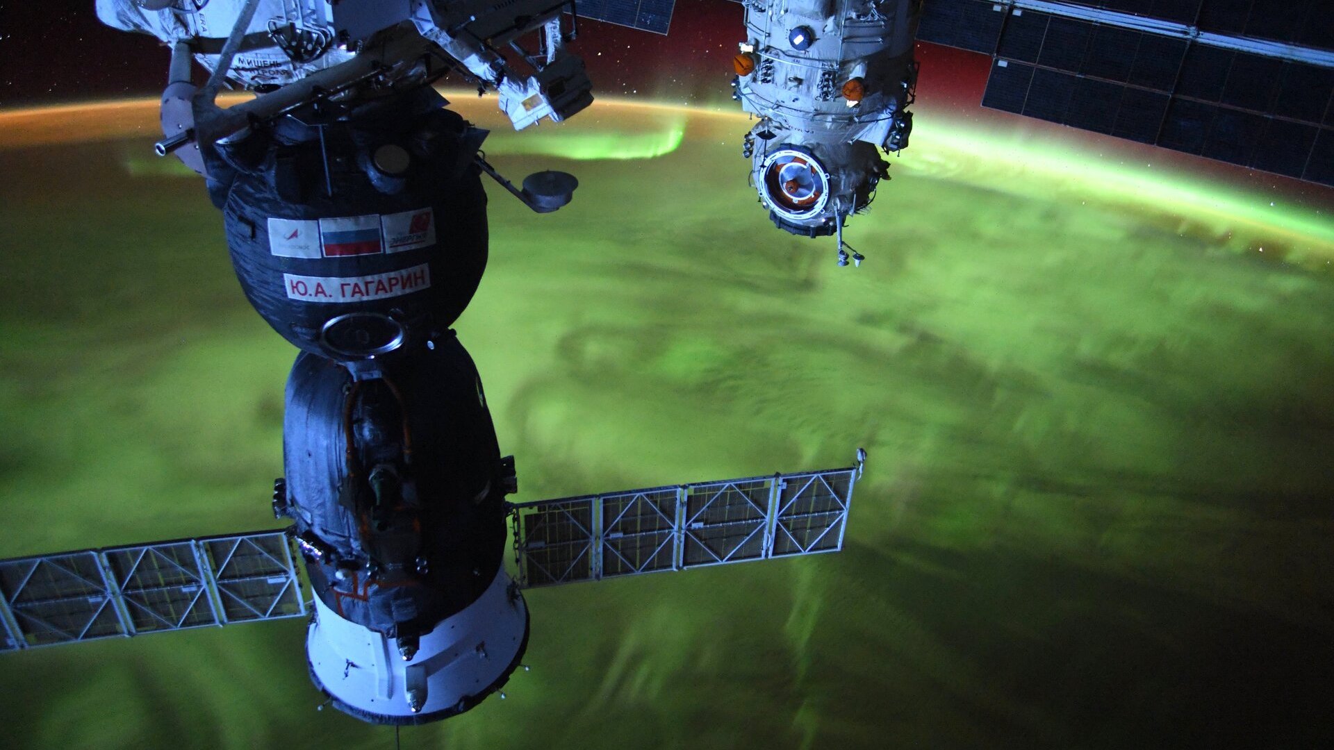 Фотография зеленого полярного сияния, покрывающего Землю, вид с Международной космической станции.