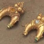gold earrings in the dirt