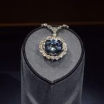 A large blue diamond encircled with smaller white diamonds as see at a museum.
