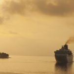 A cruise ship sails off the coast of Corfu with a yellow, smoggy sky.